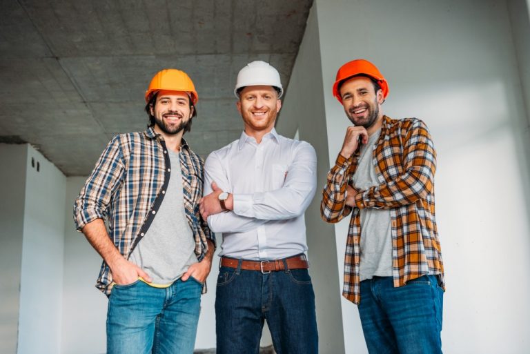 Group of men waering hard hats and smiling