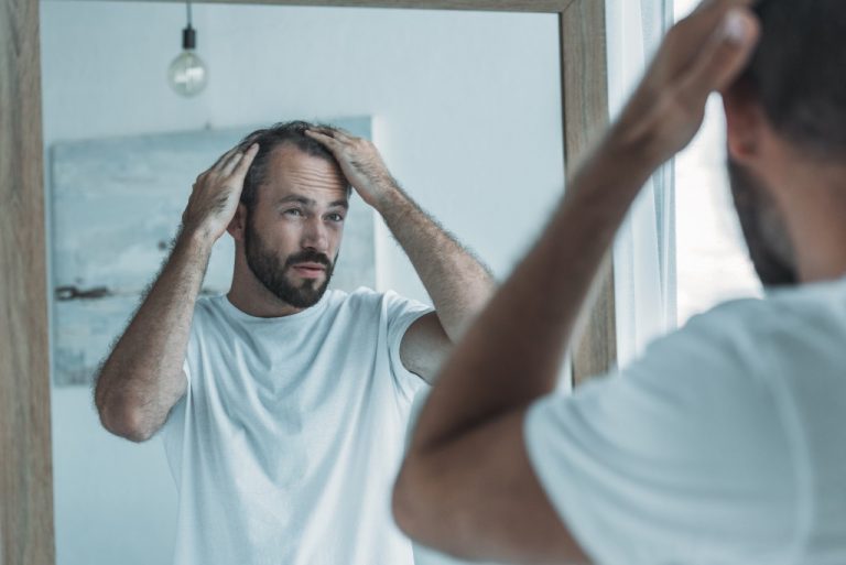 Man looking at his hair in the mirror