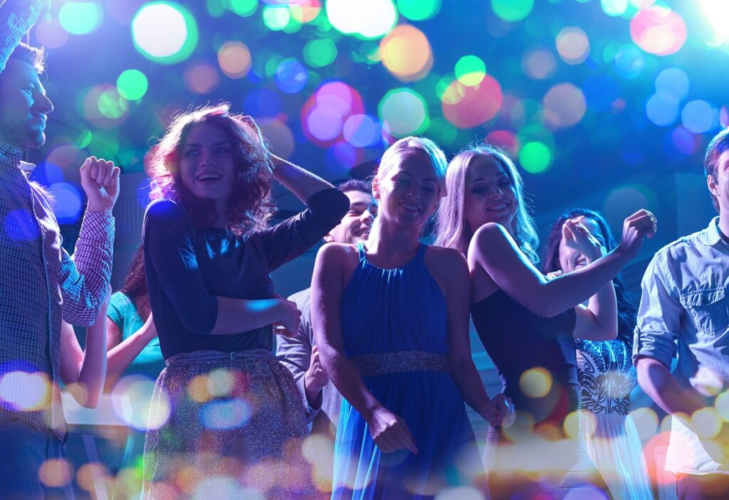 happy friends dancing in night club
